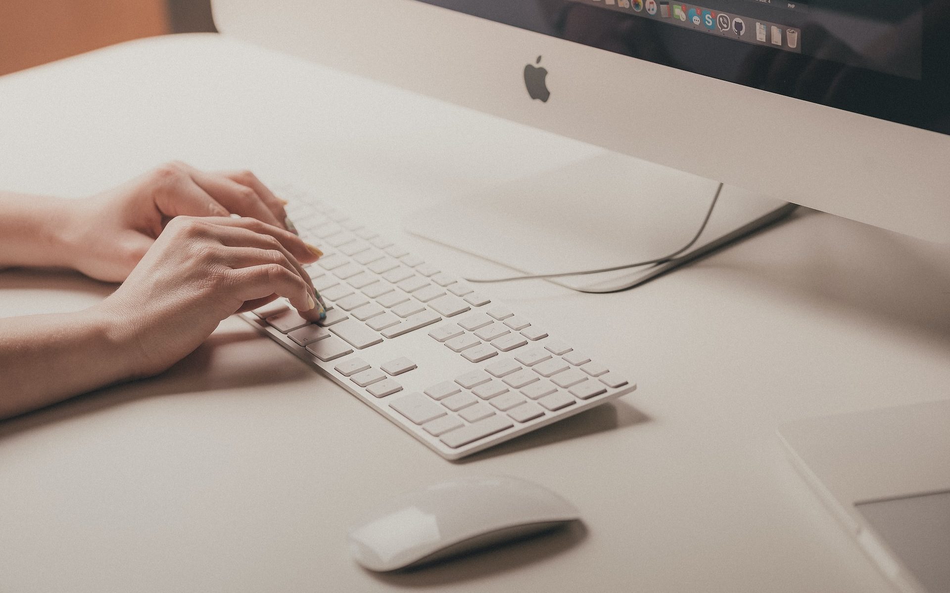 person typing on Apple keyboard