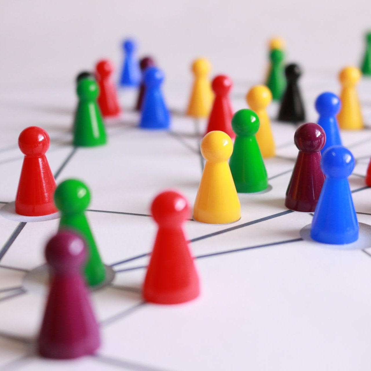 Close Up Photography of Yellow Green Red and Brown Plastic Cones on White Lined Surface